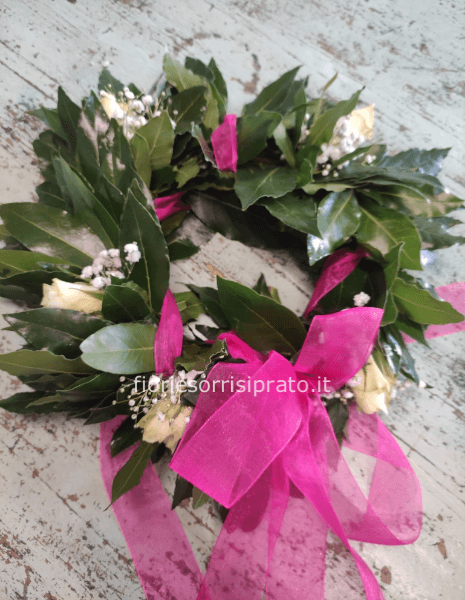 Corona d'alloro con roselline bianche, gyspophila e nastro fucsia